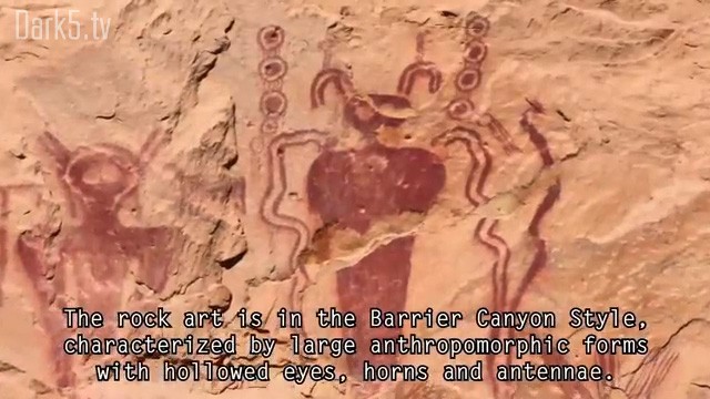 The rock art is in the Barrier Canyon Style, characterized by large anthropomorphic forms with hollowed eyes, horns, and antennae.